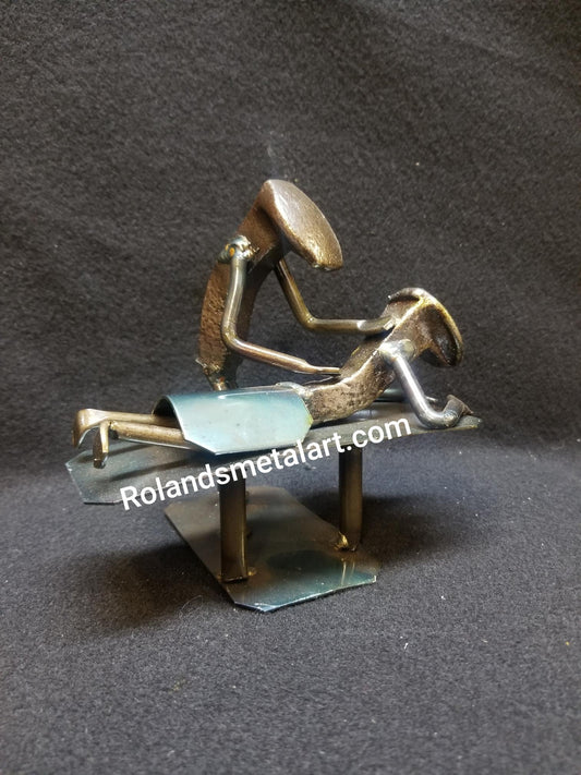 masseuse working on a patients back on table metal spike art product photo