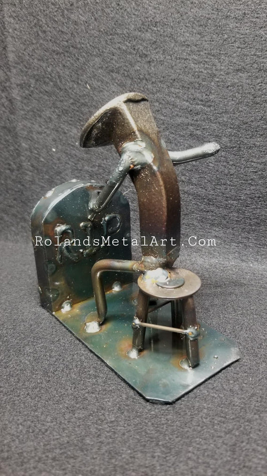 graveyard worker chiseling something on a tombstone metal spike art product photo