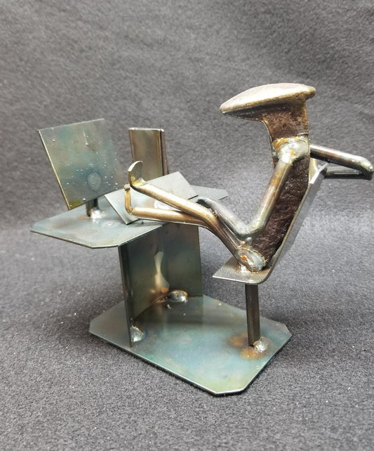 Computer with legs kicked up on desk metal spike art product photo