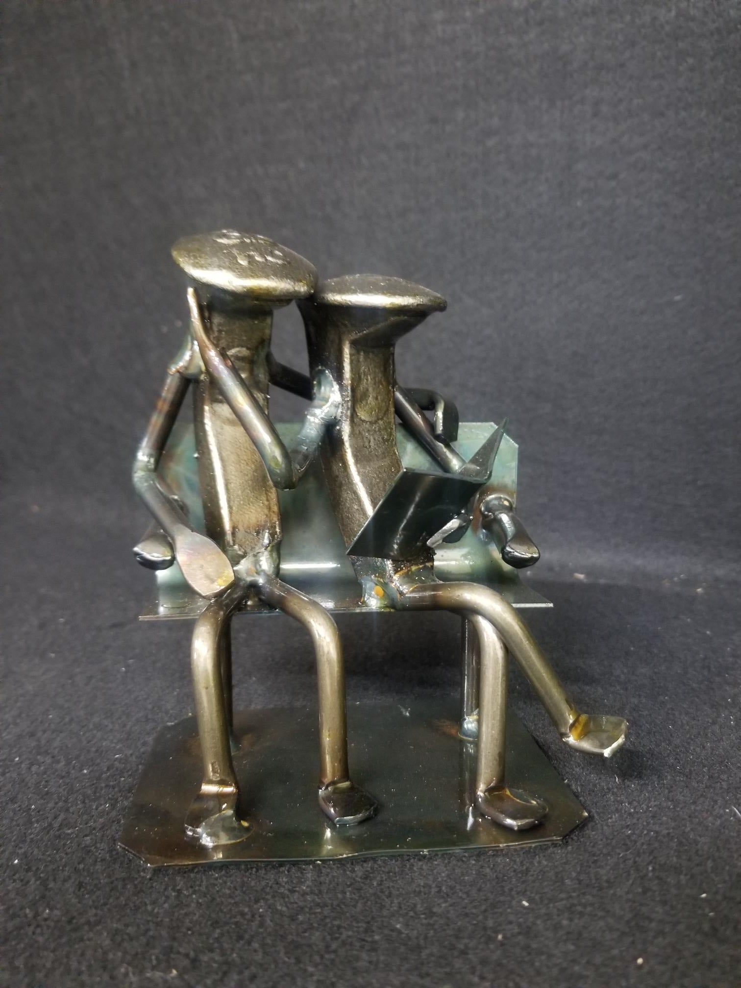 Couple sitting on bench reading a book railroad spike metal art