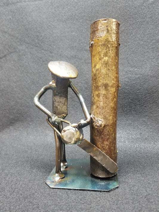 lumber jack with chainsaw near a tree metal spike art product photo