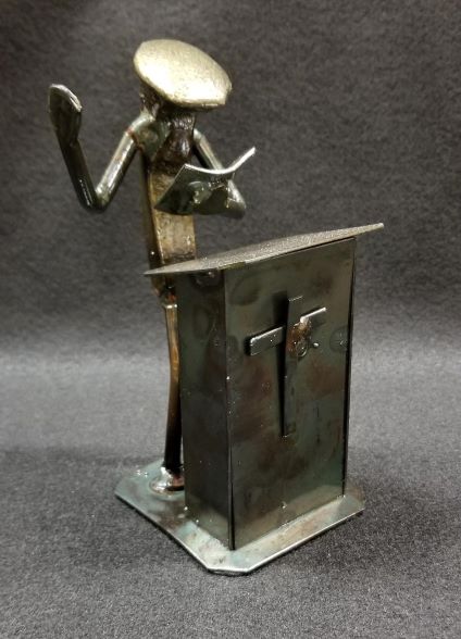 Preacher standing at the podium with book in hand metal spike art product photo