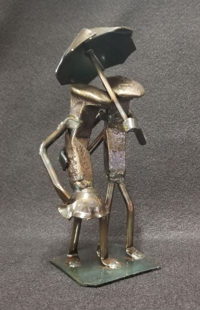 A couple holding each other with an umbrella safeguarding them metal spike art product photo