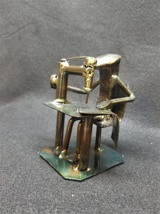 seamstress sitting at desk with their sowing machine metal spike art product photo