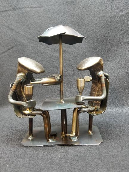 2 spike people sitting at the table enjoying a glass of wine with each other metal spike art product photo
