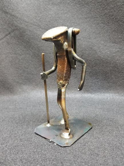 Hiker with backpack on metal spike art product photo
