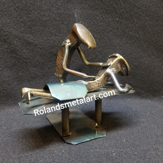 masseuse working on a patients back on table metal spike art product photo