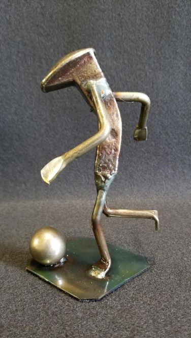 soccer player in mid kick form with ball on the ground metal spike art product photo