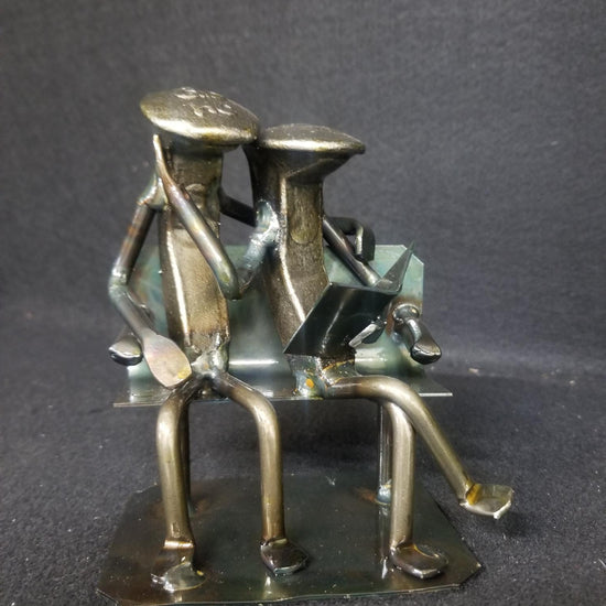 Couple sitting on bench reading a book railroad spike metal art