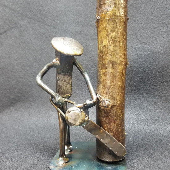 lumber jack with chainsaw near a tree metal spike art product photo