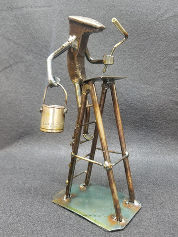 painter standing on their ladder holding the paint and roller metal spike art product photo