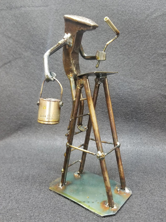 painter standing on their ladder holding the paint and roller metal spike art product photo