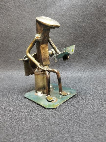 Reader on the toilet reading magazine angled shot metal spike art product photo