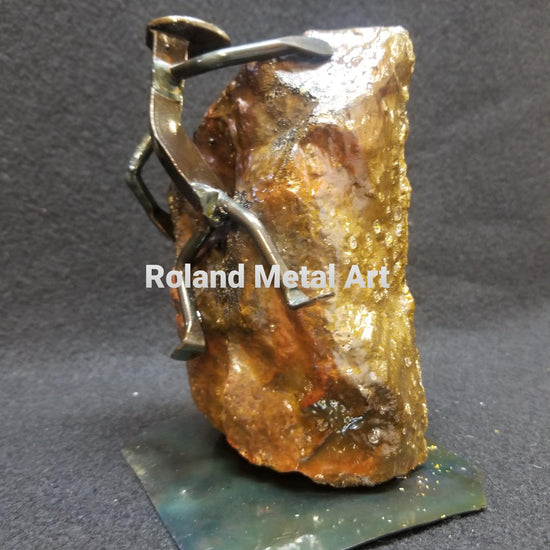 rockclimber in mid climb of object metal spike art product photo