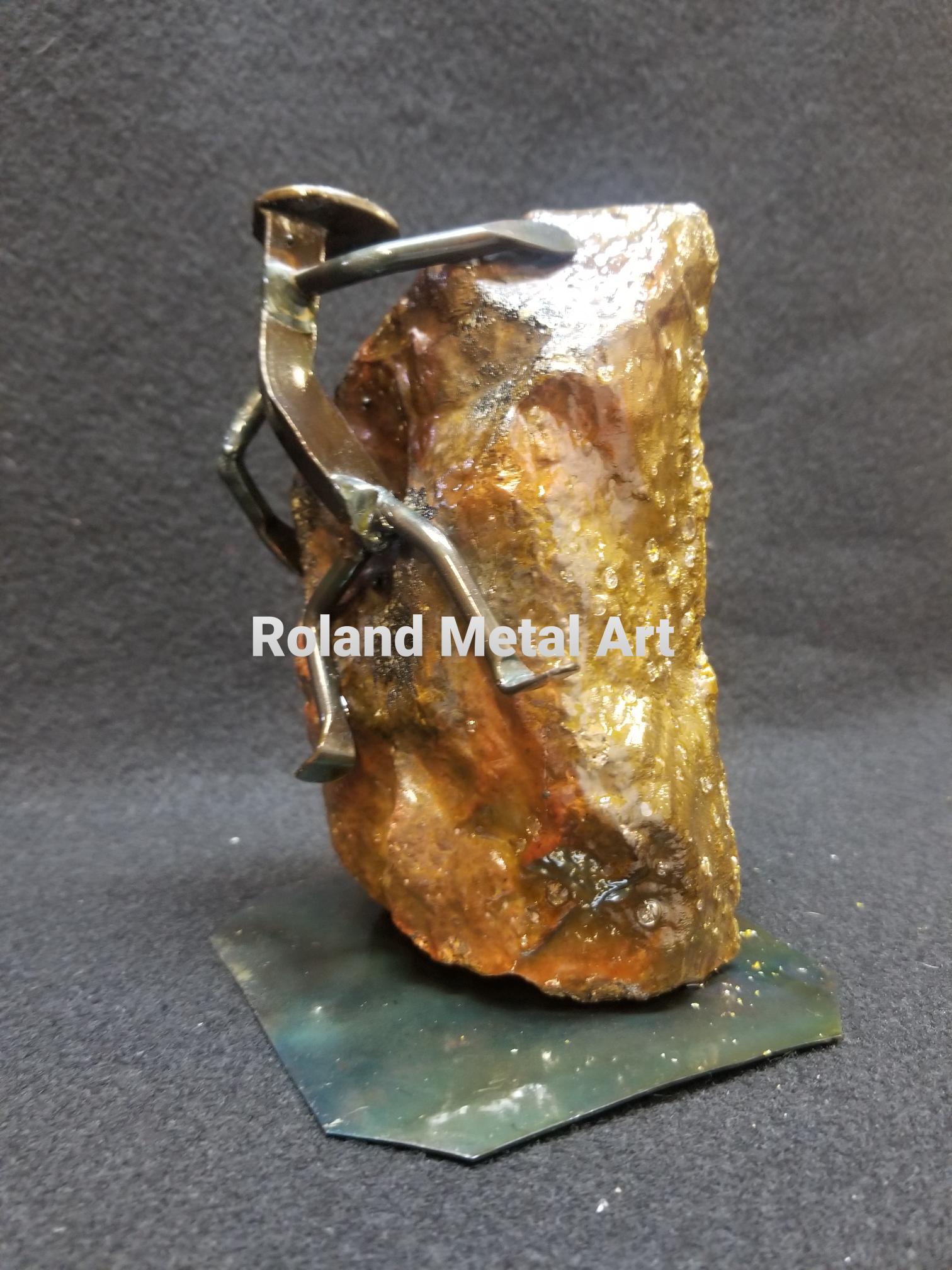 rockclimber in mid climb of object metal spike art product photo